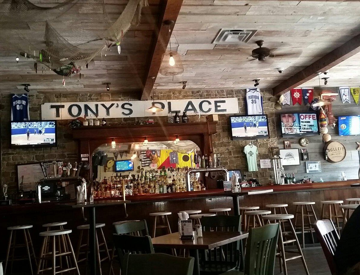Inside Reel Bar — the bar, Tony’s Place sign, and island décor
